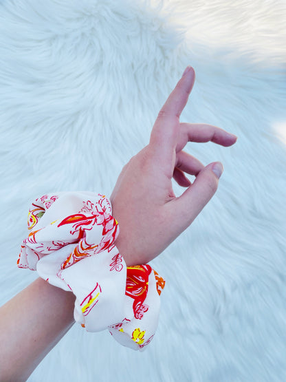 POPPY|EMI AND CO| White and orange floral scrunchie on wrist 