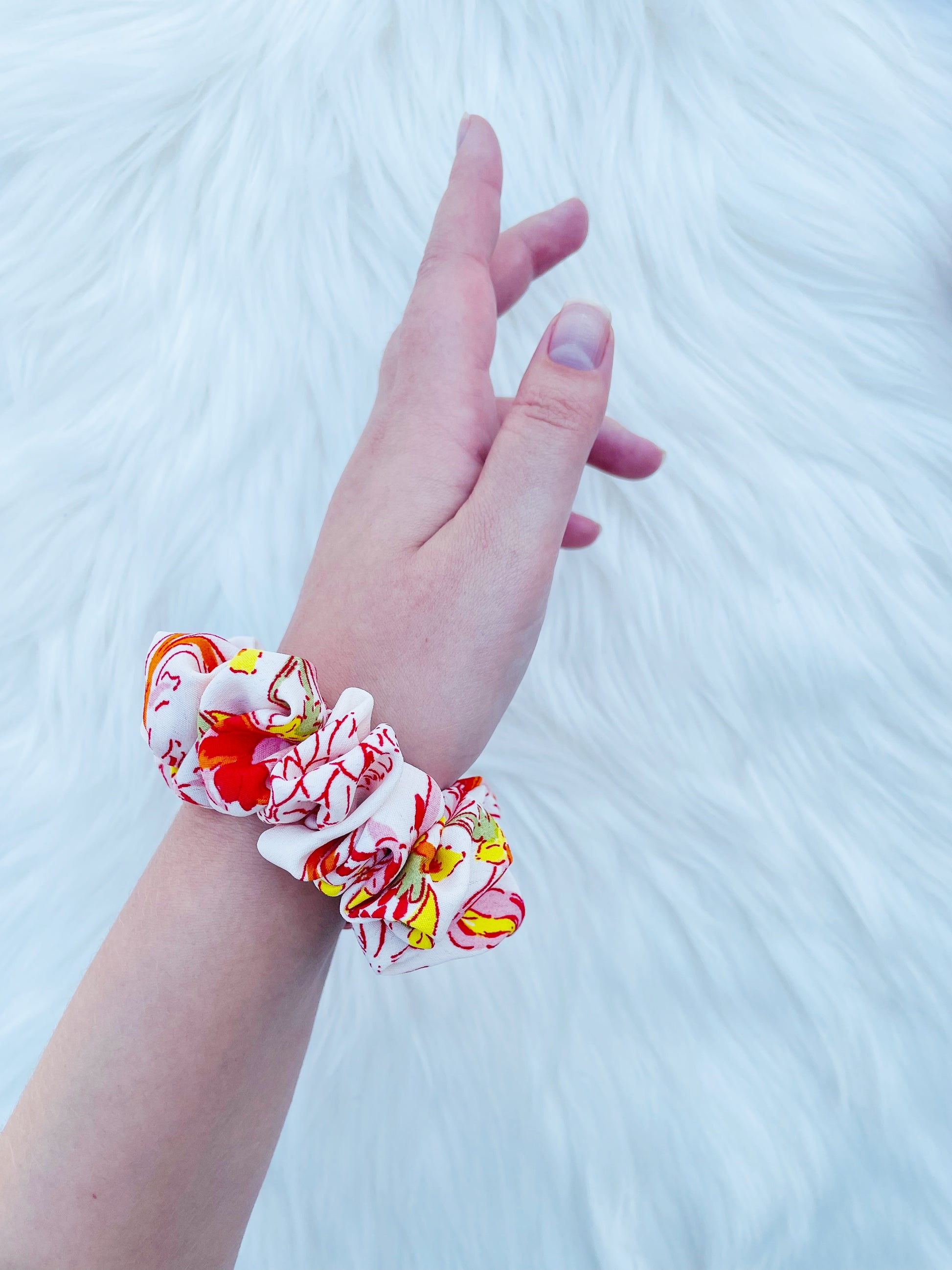 POPPY MINI|EMI AND CO| Mini white and orange floral scrunchie on wrist 