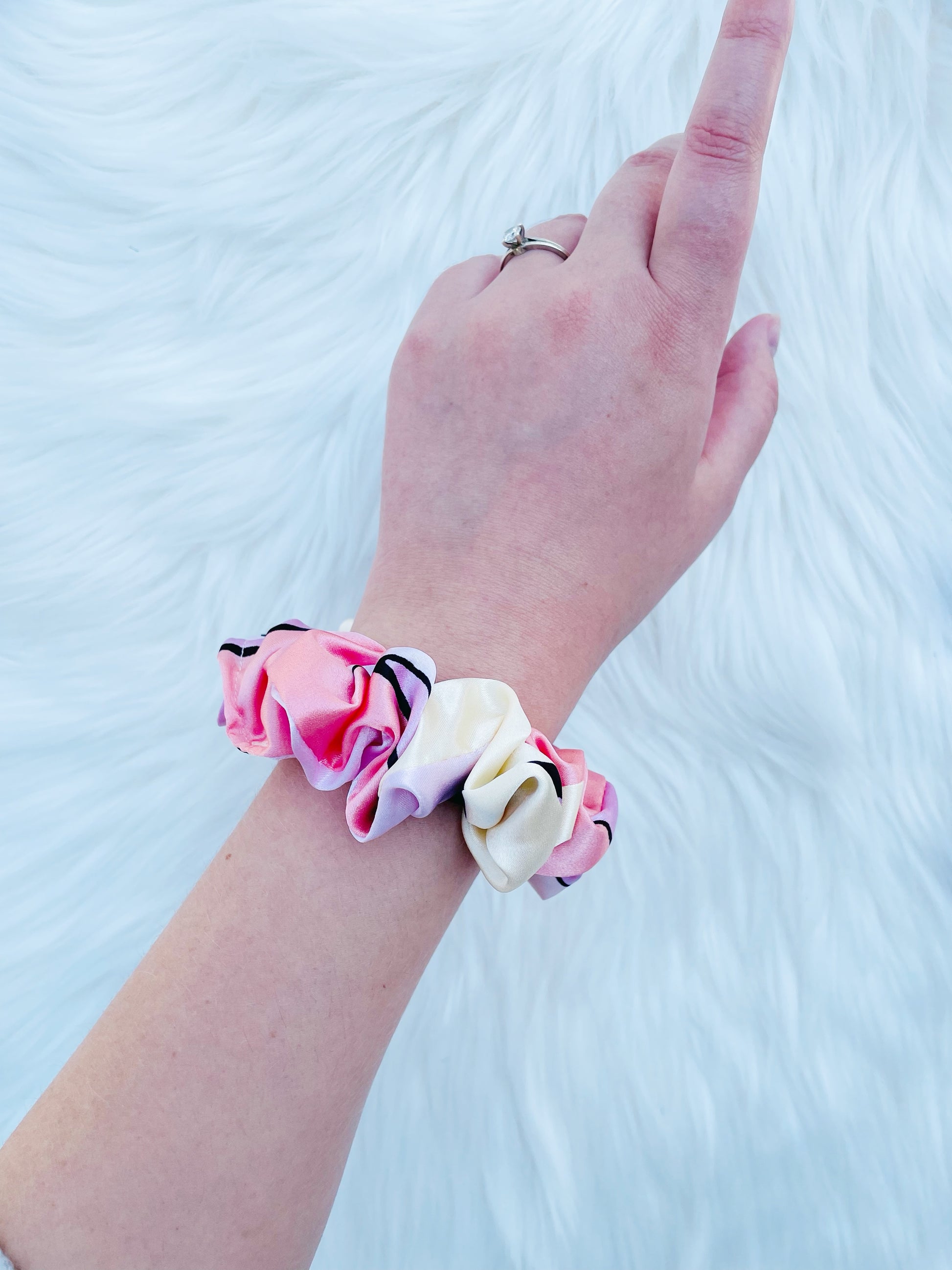 SCOUT MINI| EMI AND CO |mini pink pattern satin scrunchie  on wrist 