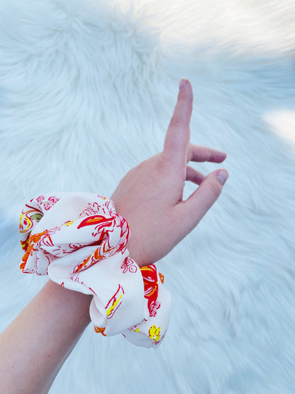 POPPY|EMI AND CO| White and orange floral scrunchie on wrist 