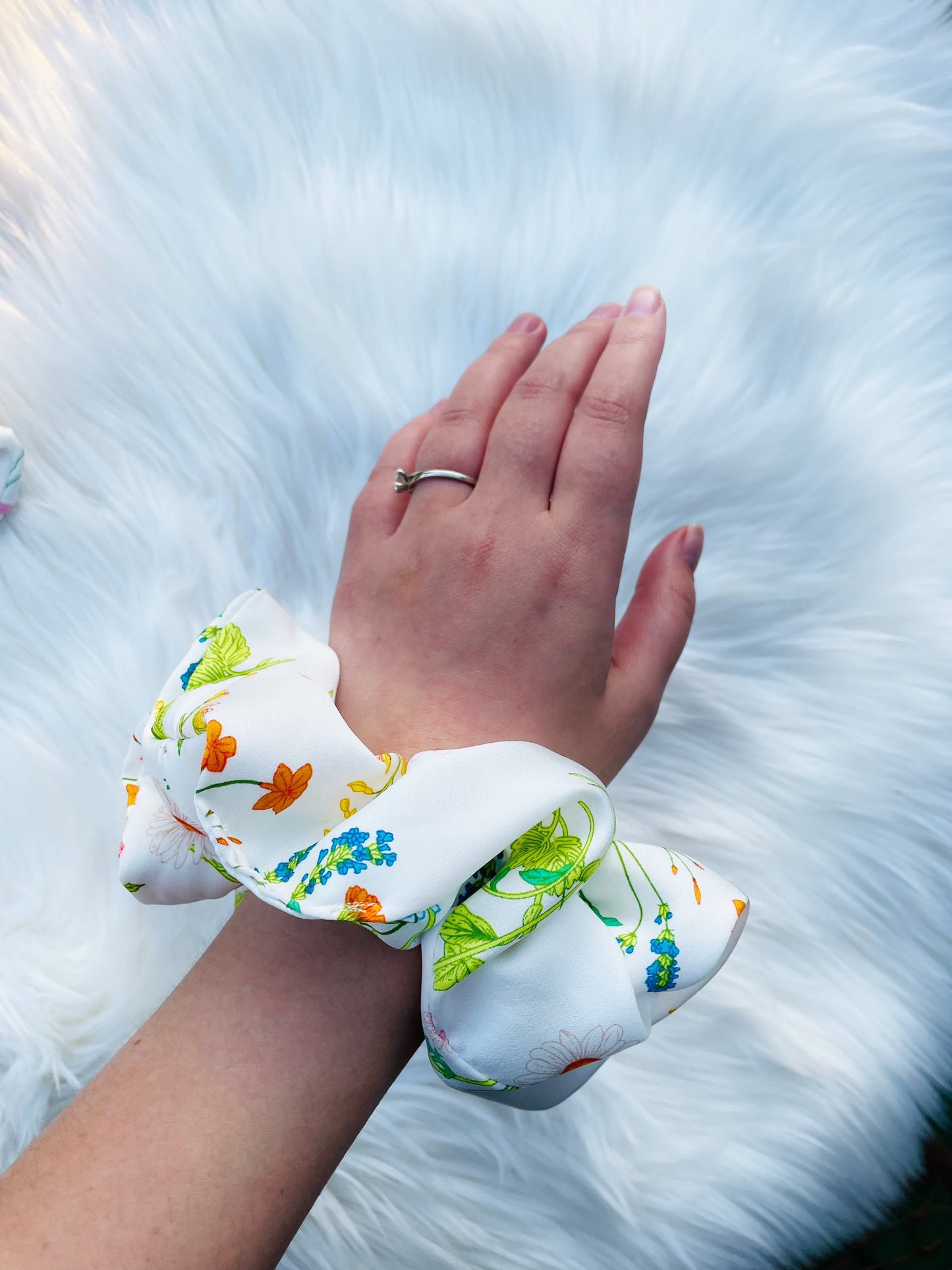 KAYA| EMI AND CO | orange, white and green floral scrunchie on wrist 