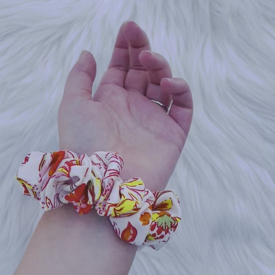 POPPY MINI|EMI AND CO| Mini white and orange floral scrunchie on wrist 