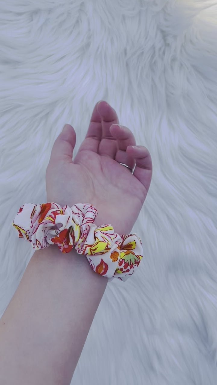 POPPY MINI|EMI AND CO| Mini white and orange floral scrunchie on wrist 