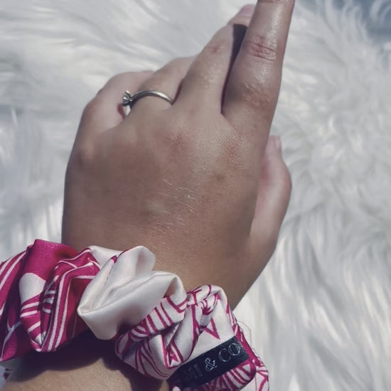 ITZAYANA| EMI AND CO | Pink and white floral satin scrunchie on wrist 