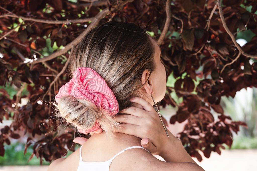 AVERY | EMI & CO | woman with a messy low bun in a pink scrunchie 