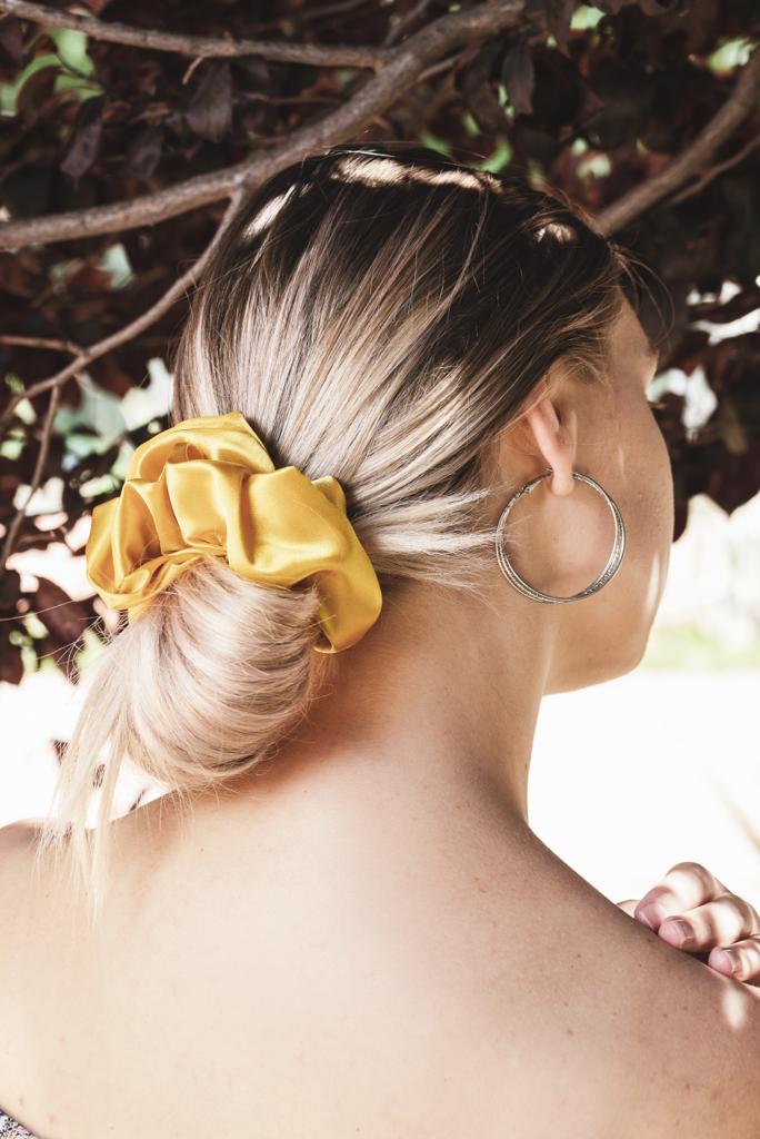 AUTUMN | EMI & CO | woman with a messy bun in a yellow satin scrunchie