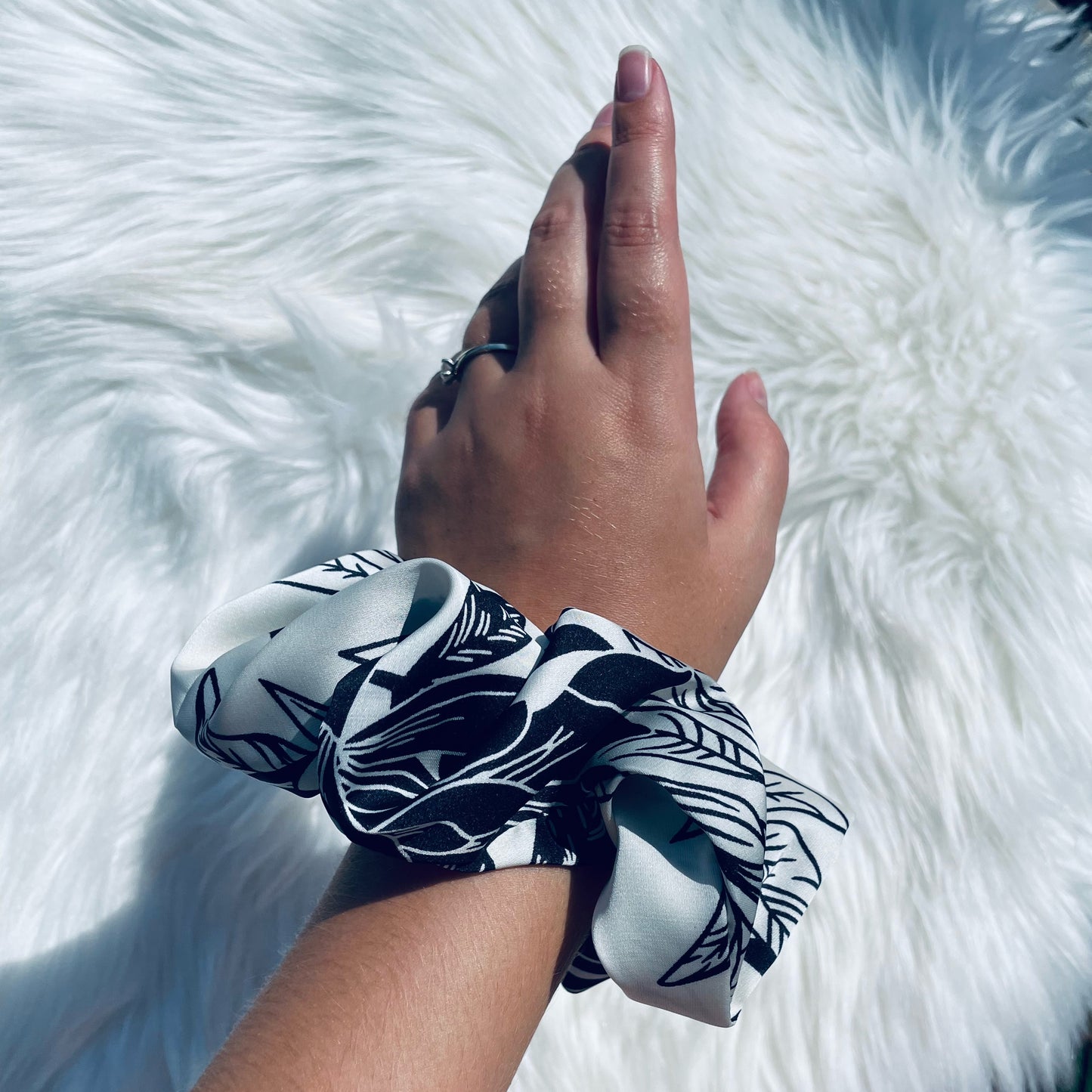 BAMBI | EMI AND CO| floral satin black and white scrunchie on wrist 